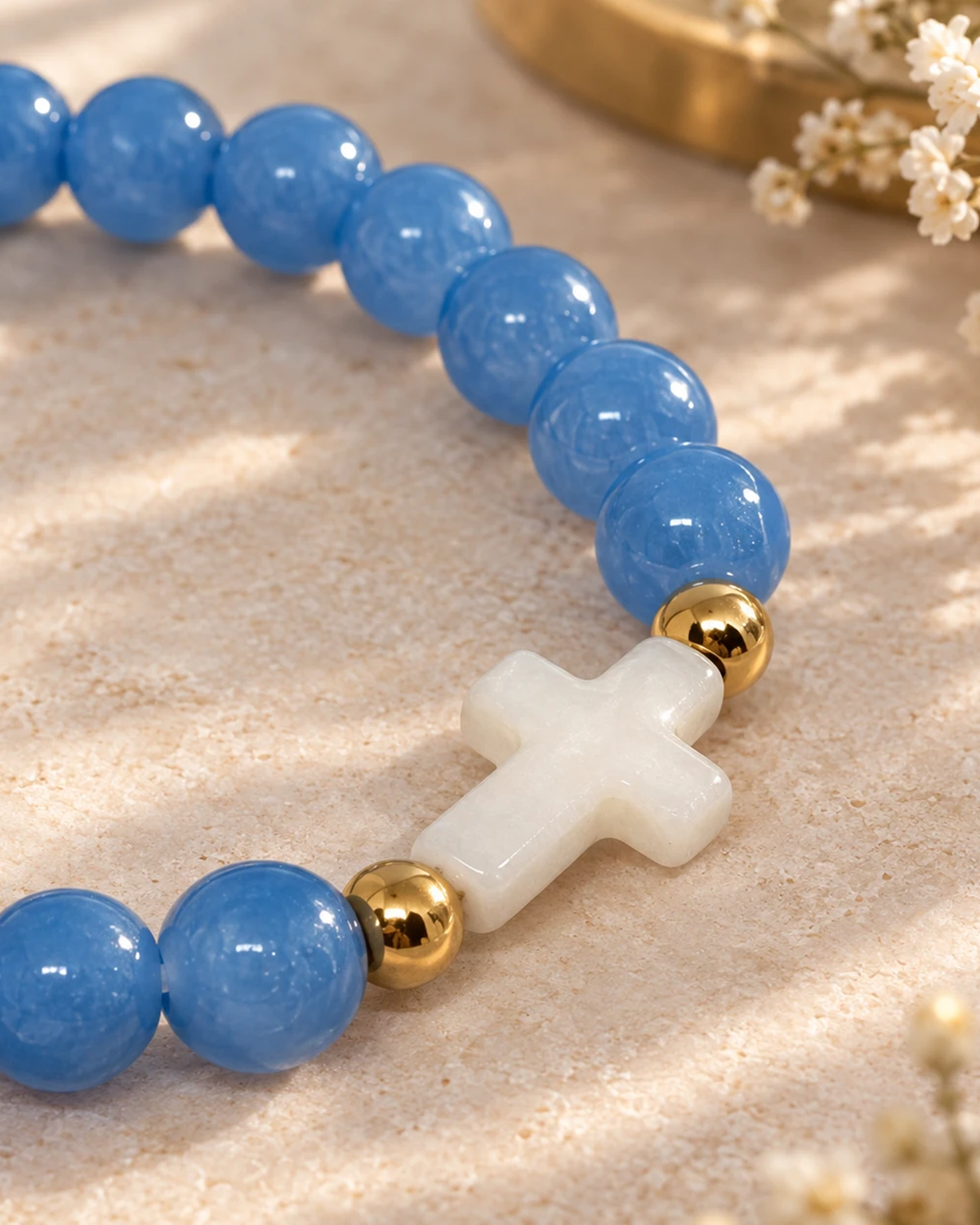 Gros plan sur la croix nacrée du bracelet Bleu et Doré