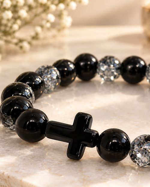Gros plan sur la croix noire du bracelet Noir Éclat Cristal