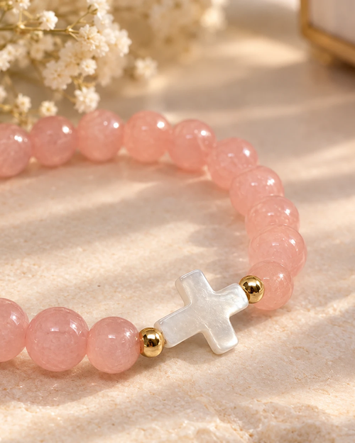 Gros plan sur la croix nacrée du bracelet Rose et Doré