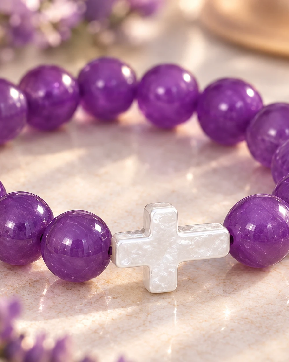 Gros plan sur la croix blanche du bracelet violet et blanc